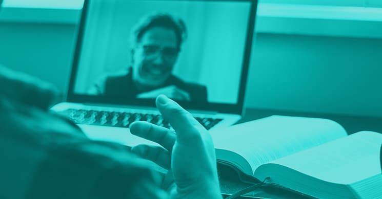 man on zoom with book technology at home