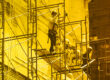 Two men on scaffolding doing construction on a building. Representing cybersecurity frameworks like NIST CSF 2.0.