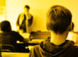 monochromatic yellow photo of the back of a young boy's head in a classroom signifying security awareness training for teachers