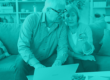 a teal monotone image of an older couple looking at a computer together with a credit card in hand to represent cybersecurity for older adults