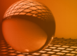 A glass ball on a keyboard-like structure with an orange overlay, signifying cybersecurity trends and predictions