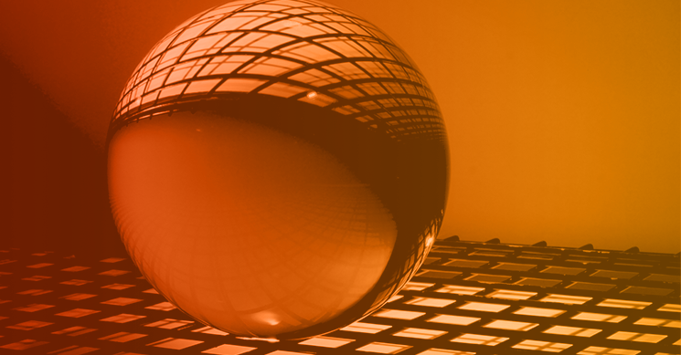 Cybersecurity Industry Trends A glass ball on a keyboard-like structure with an orange overlay, signifying cybersecurity trends and predictions